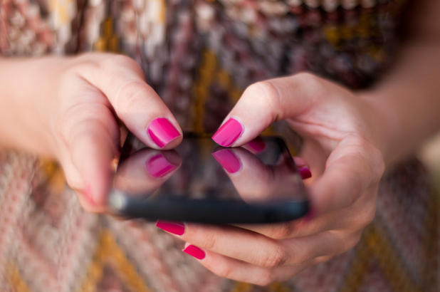 Frau tippt am Smartphone